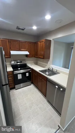 a kitchen with stainless steel appliances granite countertop a sink stove and cabinets