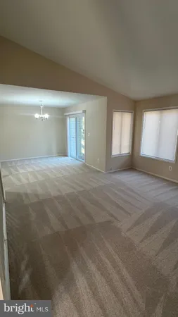 a view of an empty room with window and fireplace