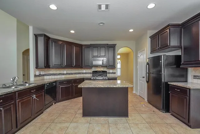 a kitchen with stainless steel appliances granite countertop a sink counter space cabinets and a large window
