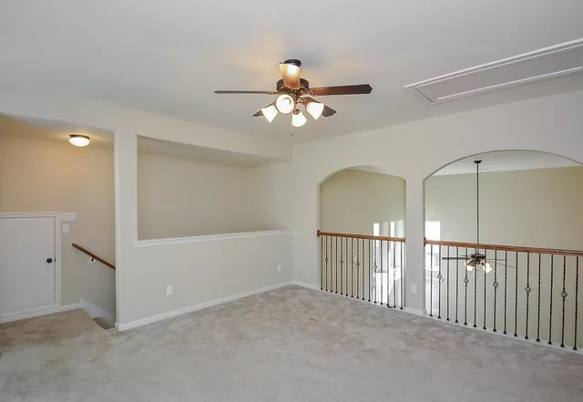 a view of a room with a ceiling fan and window