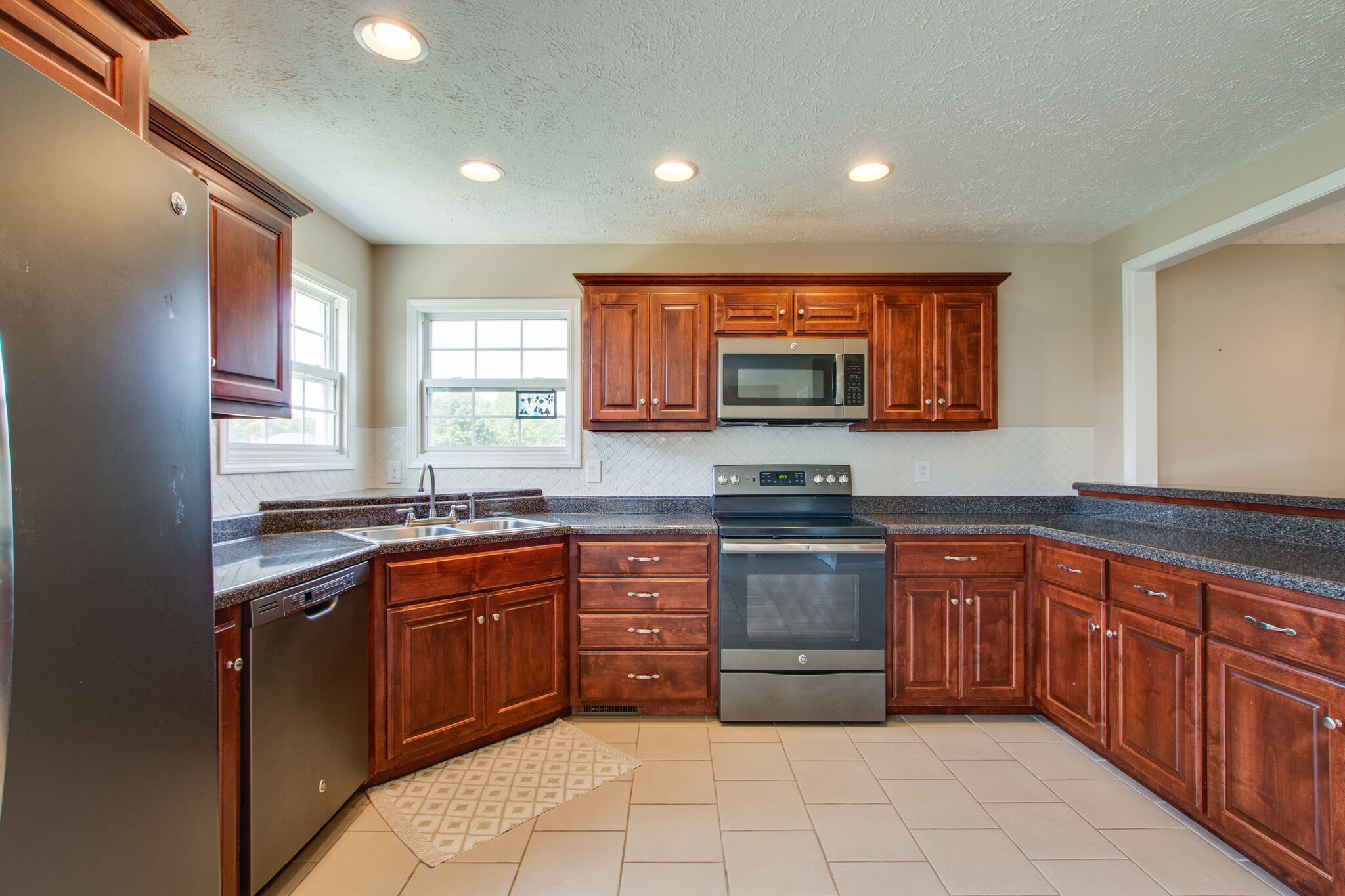 84 Houston Bell Road Manchester, TN 37355 - Photo 11 of 36 a kitchen with stainless steel appliances granite countertop wooden cabinets a sink and dishwasher a stove top oven with wooden floor