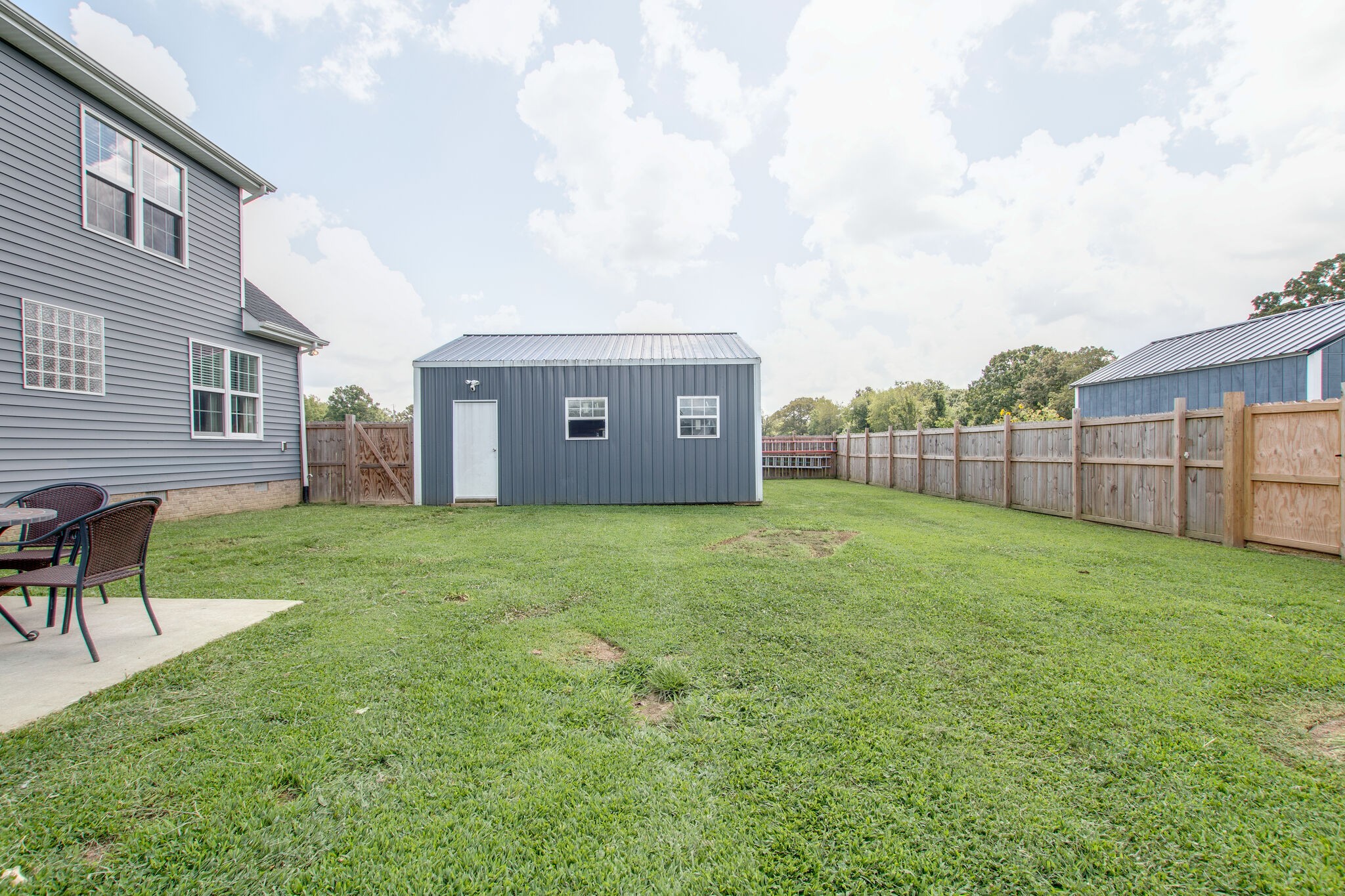 84 Houston Bell Road Manchester, TN 37355 - Photo 31 of 36 a view of a backyard with table and chairs and wooden fence