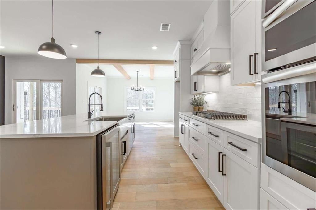 5808 Swinging Gate Road Gainesville, GA 30506 - Photo 15 of 59 a large kitchen with stainless steel appliances kitchen island granite countertop a sink and cabinets