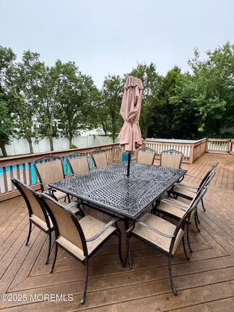 a view of a roof deck with table and chairs with wooden floor and fence
