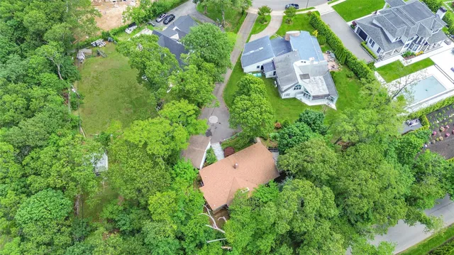 an aerial view of a house with a yard and large trees