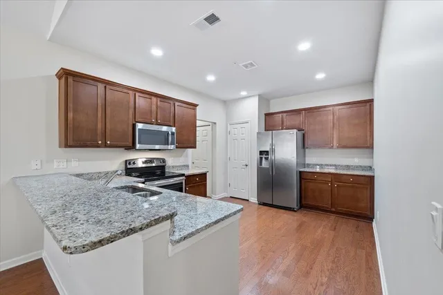 a kitchen with granite countertop stainless steel appliances and wooden cabinets