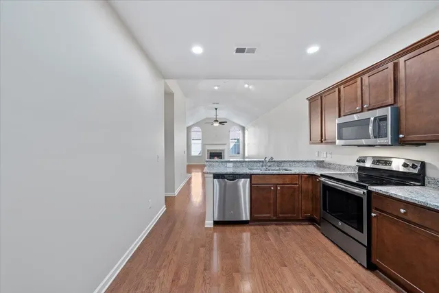 a kitchen with stainless steel appliances granite countertop a stove cabinets and microwave