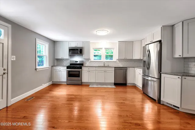 a kitchen with a refrigerator and a stove top oven