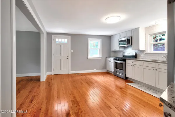 a view of an empty room with wooden floor