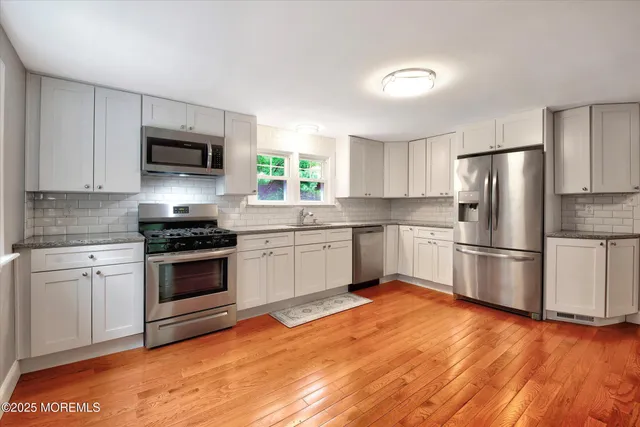 a kitchen with a white cabinets and stainless steel appliances