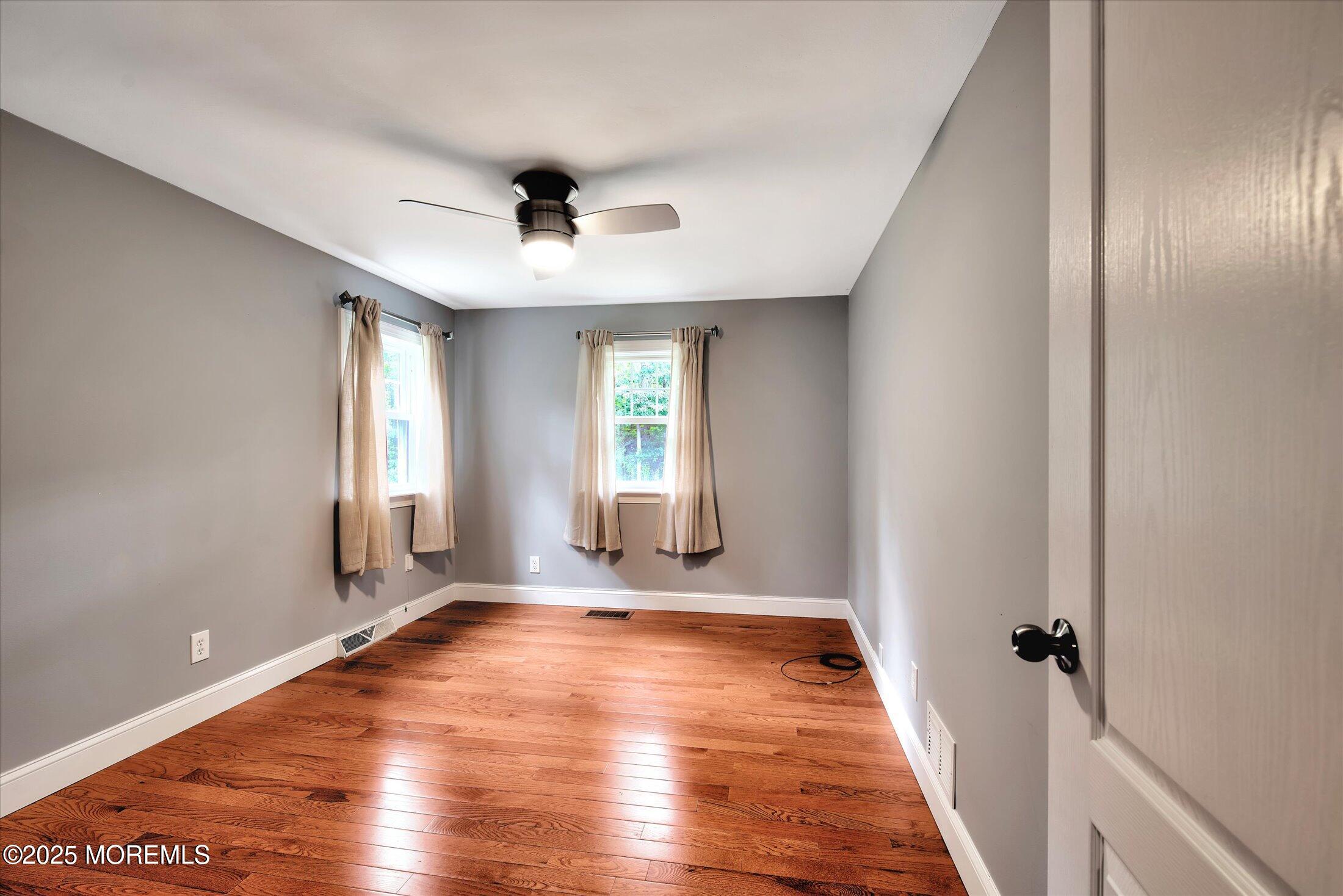 88 Dutch Lane Road Marlboro, NJ 07746 - Photo 19 of 35 an empty room with wooden floor and windows