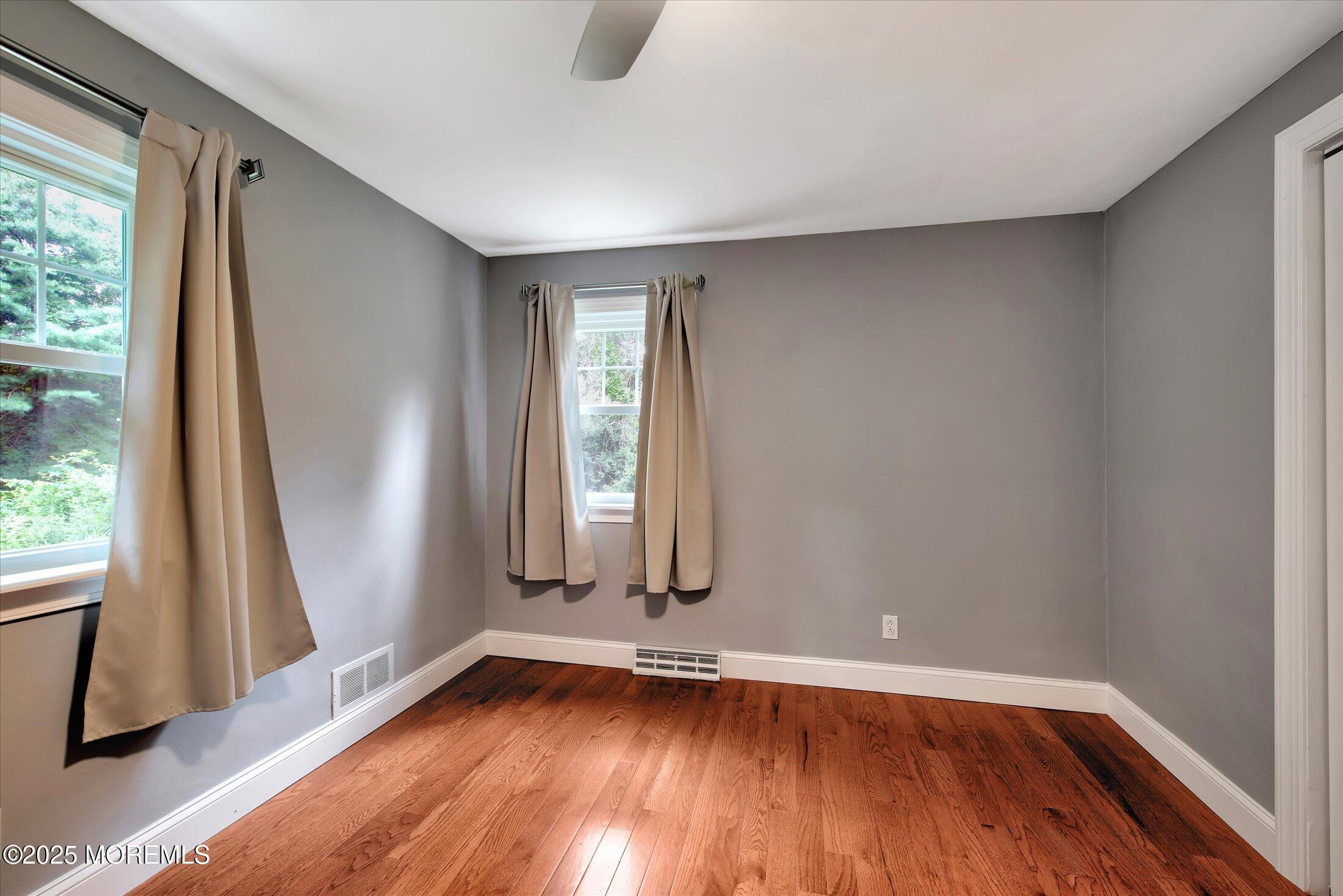 88 Dutch Lane Road Marlboro, NJ 07746 - Photo 22 of 35 an empty room with wooden floor and windows