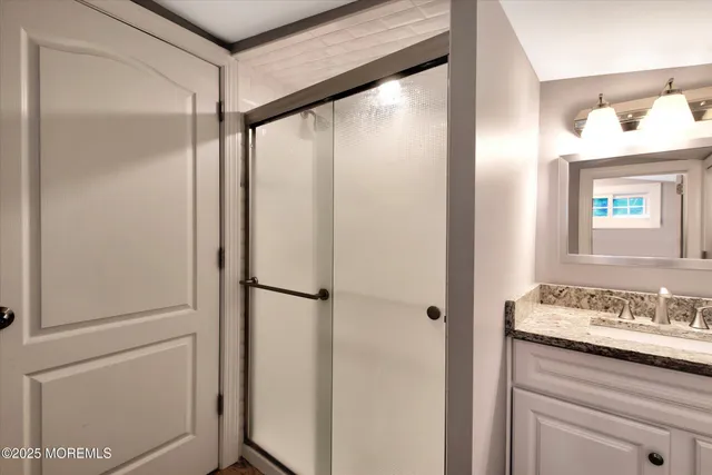 a bathroom with a shower sink and mirror