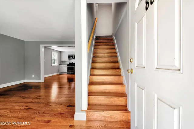 a view of entryway and hall with wooden floor