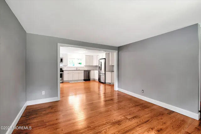 a big room with wooden floor and windows