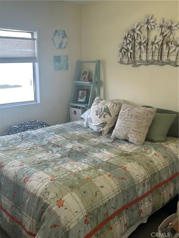 a bed sitting in a bedroom next to a window