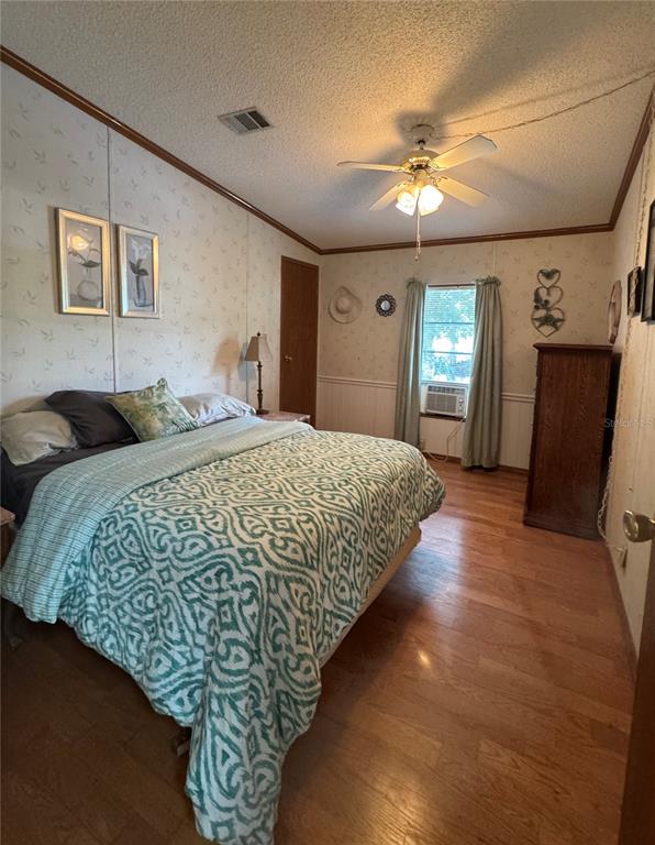 605 Michigan Boulevard, Unit 100 Dunedin, FL 34698 - Photo 17 of 20 a spacious bedroom with a bed and a chandelier