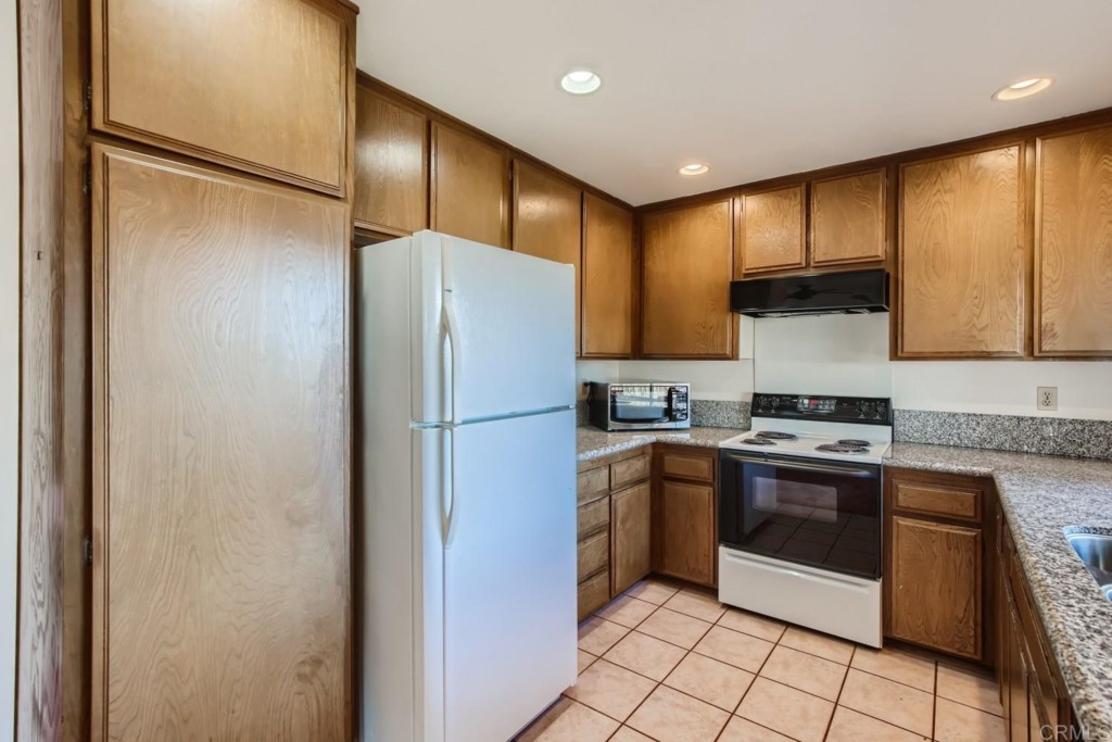 404 Compass Road Oceanside, CA 92054 - Photo 8 of 26 a kitchen with stainless steel appliances granite countertop a refrigerator a sink and a stove