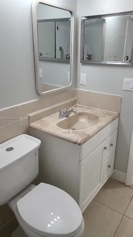 a bathroom with a toilet sink and mirror