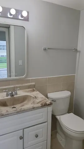a bathroom with a toilet a sink and a mirror