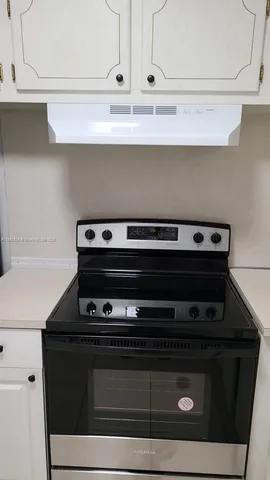 a stove top oven sitting inside of a kitchen