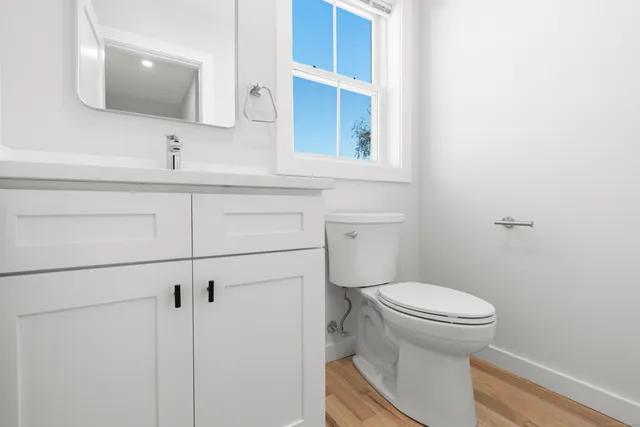 a bathroom with a toilet sink and mirror
