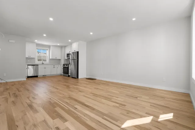 a view of empty room with wooden floor