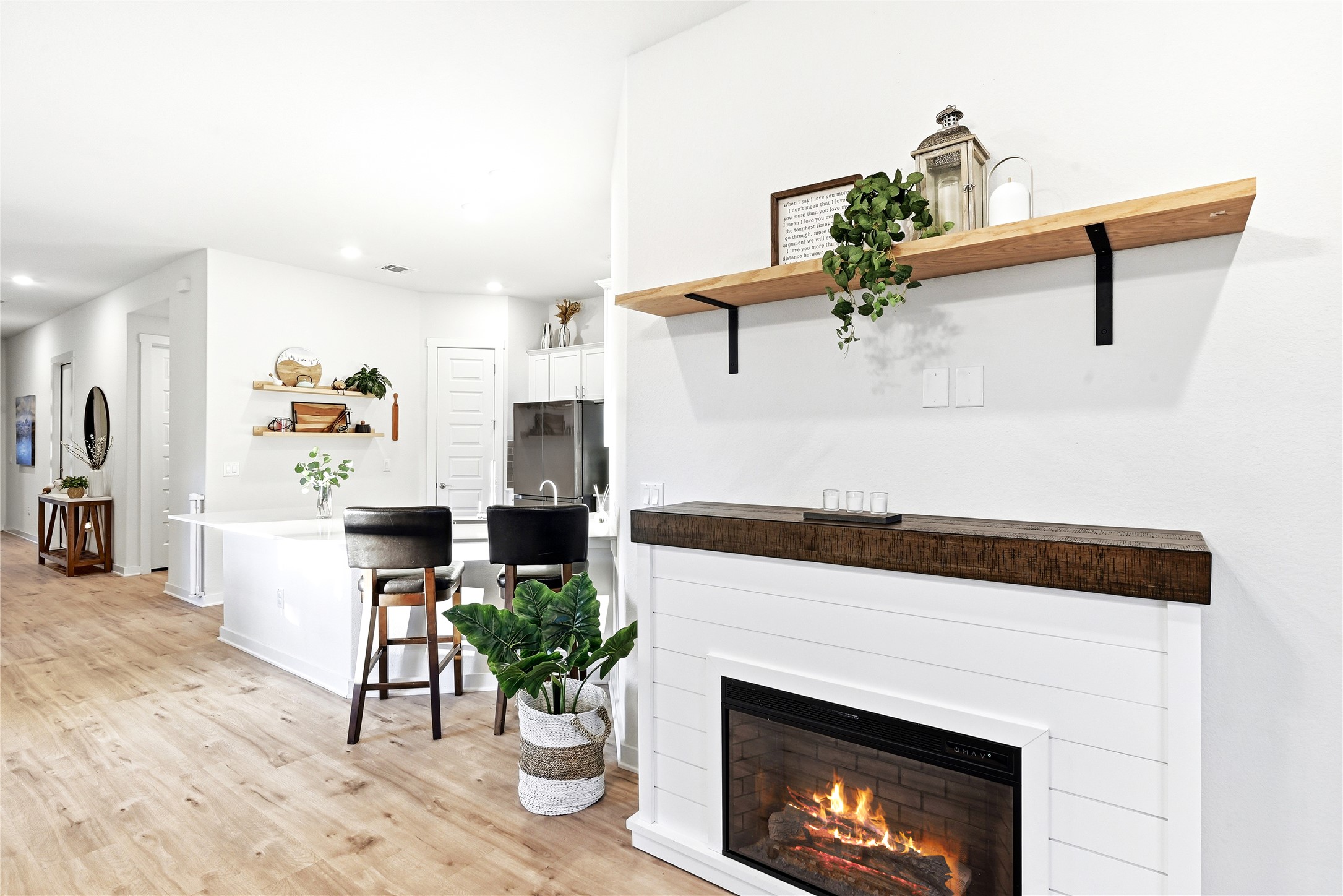 4420 Ingram Road Georgetown, TX 78628 - Photo 13 of 40 A striking fireplace with a rustic wooden mantel and sleek floating shelves anchors this bright living space.