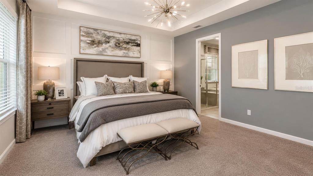 33320 Castaway Loop Wesley Chapel, FL 33543 - Photo 10 of 23 a bedroom with a bed and a chandelier