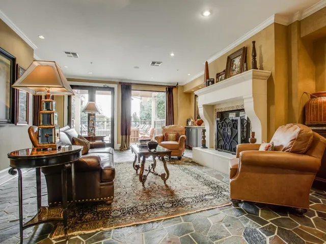 a living room with furniture fireplace and large windows