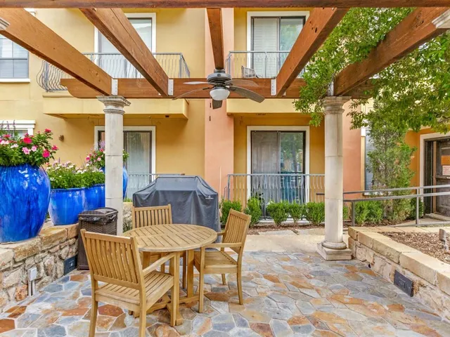 a view of a patio with table and chairs and potted plants