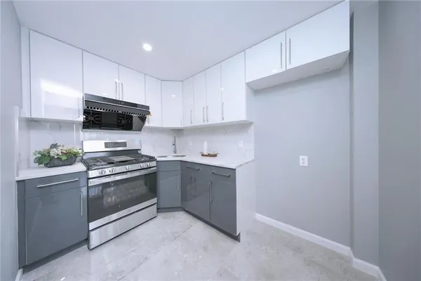 a kitchen with stainless steel appliances granite countertop a stove a sink and a microwave