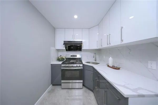 a kitchen with a sink a stove and cabinets