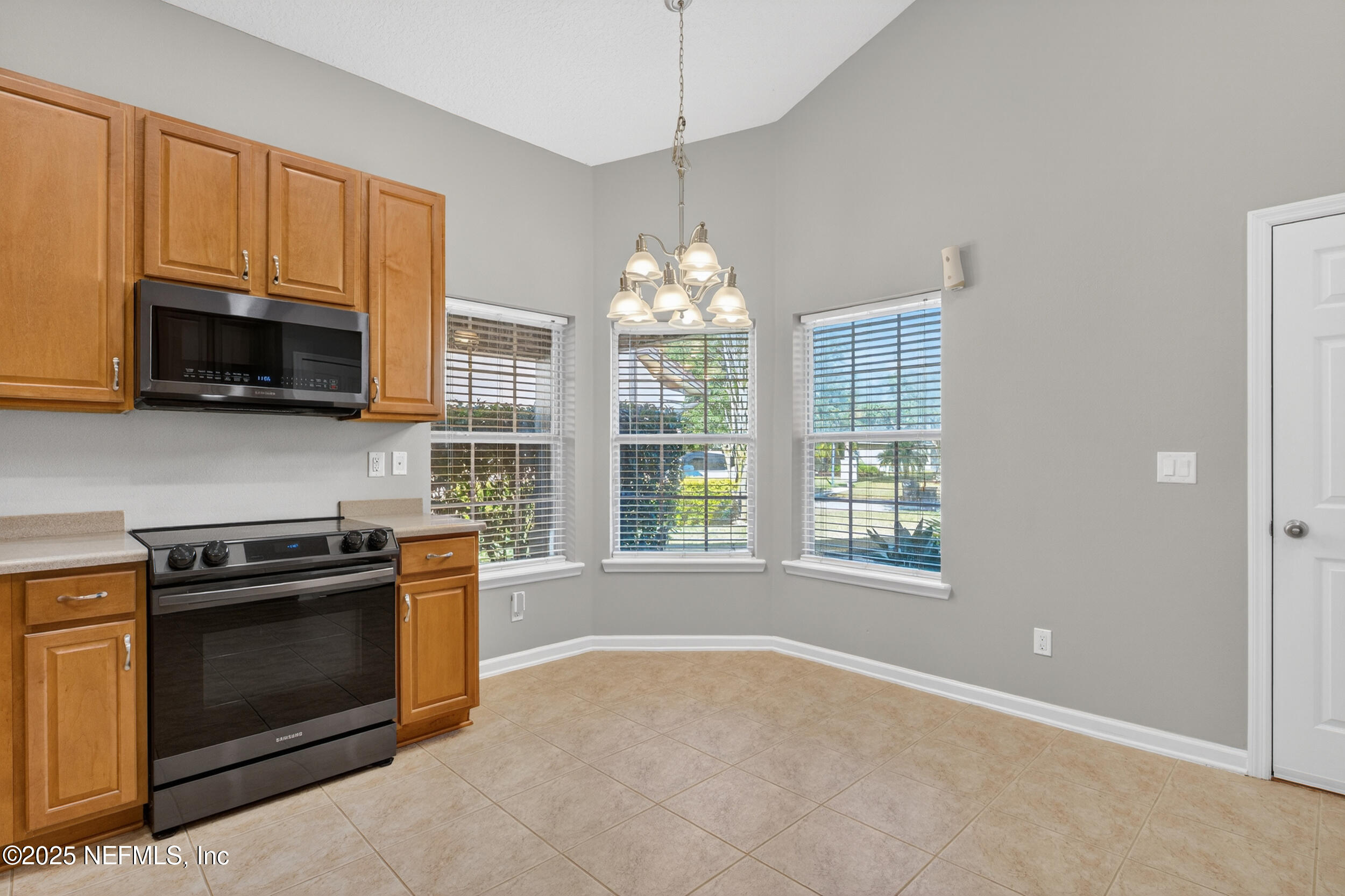 1165 Carmona Place St. Augustine, FL 32092 - Photo 17 of 31 a kitchen with stainless steel appliances granite countertop a stove top oven a sink dishwasher a microwave oven and a refrigerator with wooden floor