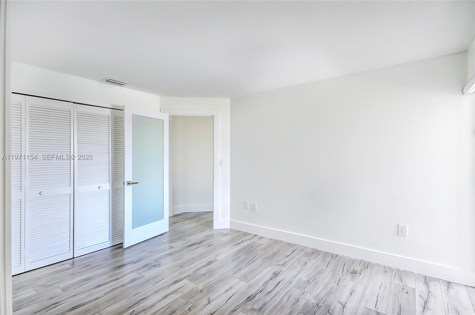 12909 Southwest 61st Terrace Miami, FL 33183 - Photo 20 of 36 a view of an empty room with wooden floor