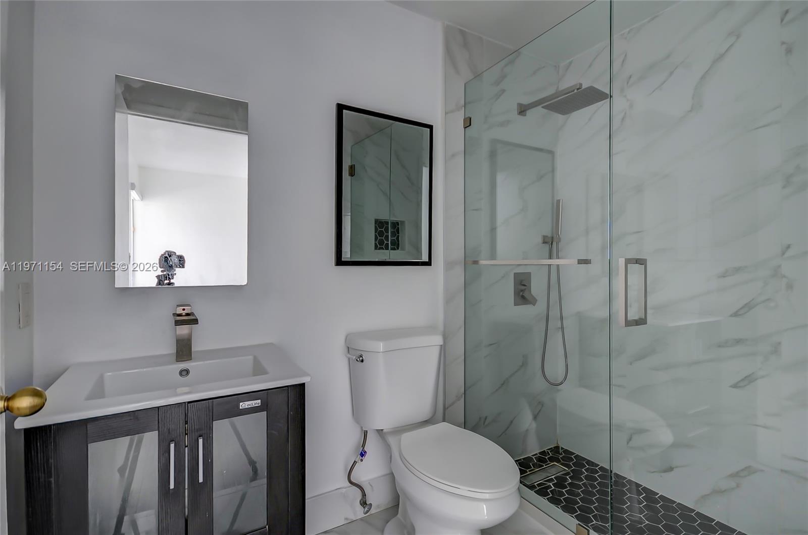 12909 Southwest 61st Terrace Miami, FL 33183 - Photo 21 of 36 a bathroom with a toilet a sink a shower and mirror