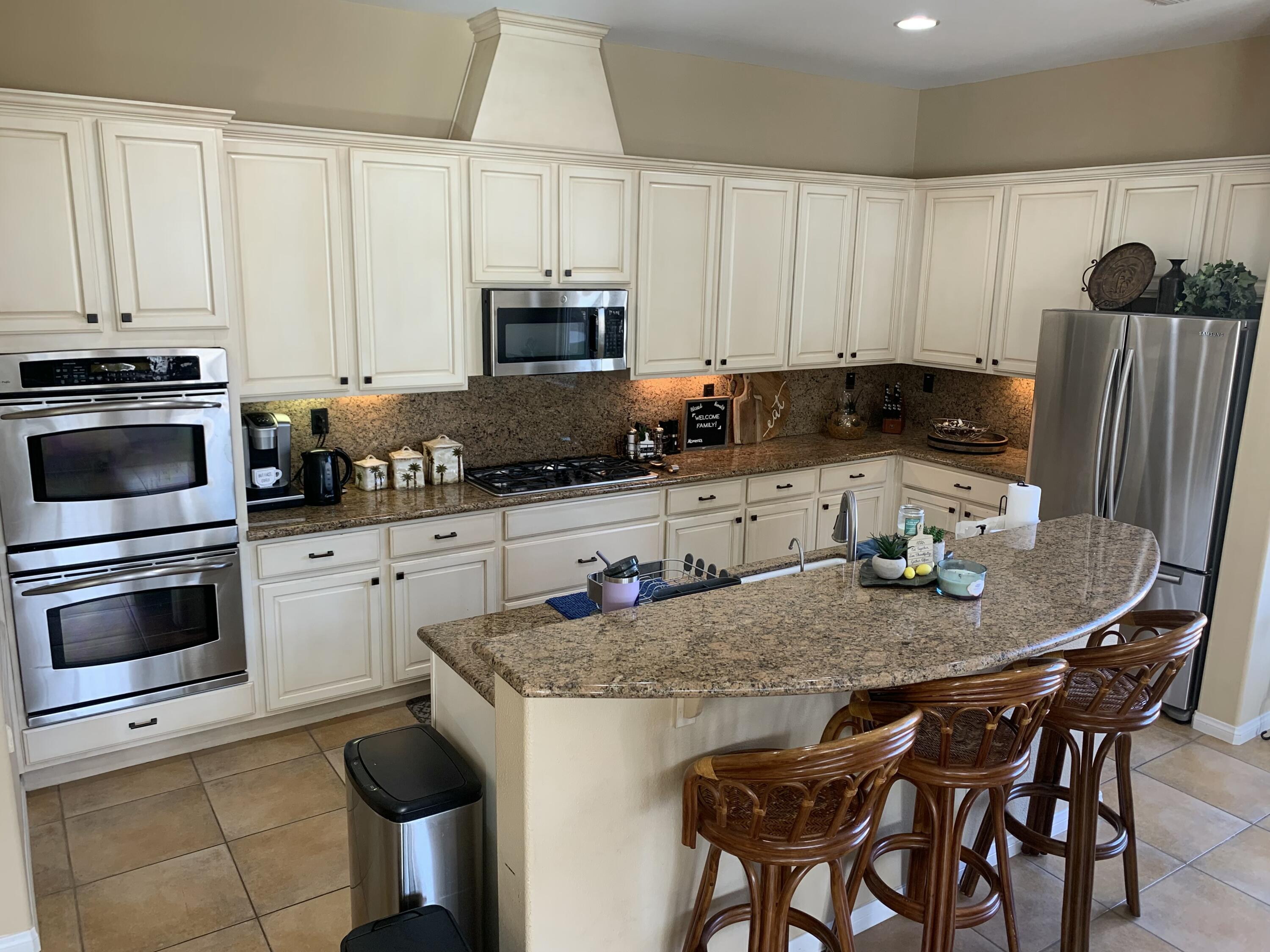 80445 Paria Way Indio, CA 92201 - Photo 31 of 70 a kitchen with granite countertop a stove a sink a microwave and dining table