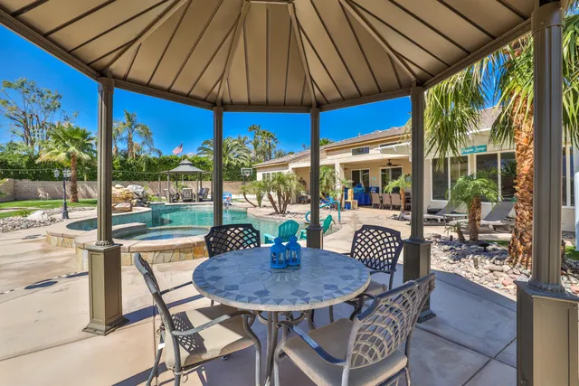 a view of a white house with a big yard and potted plants