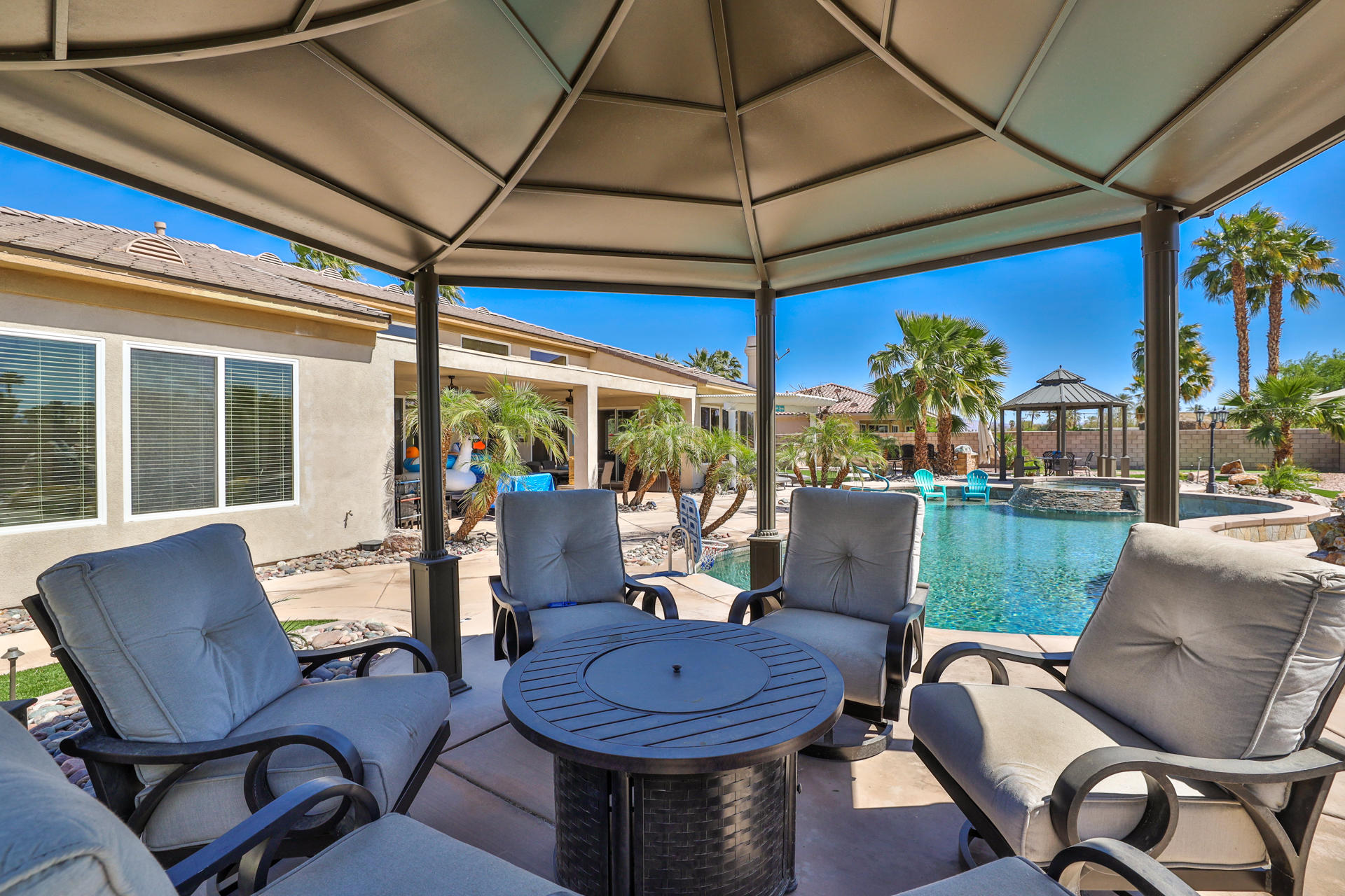80445 Paria Way Indio, CA 92201 - Photo 48 of 70 a view of a patio with a dining table chairs and a umbrella