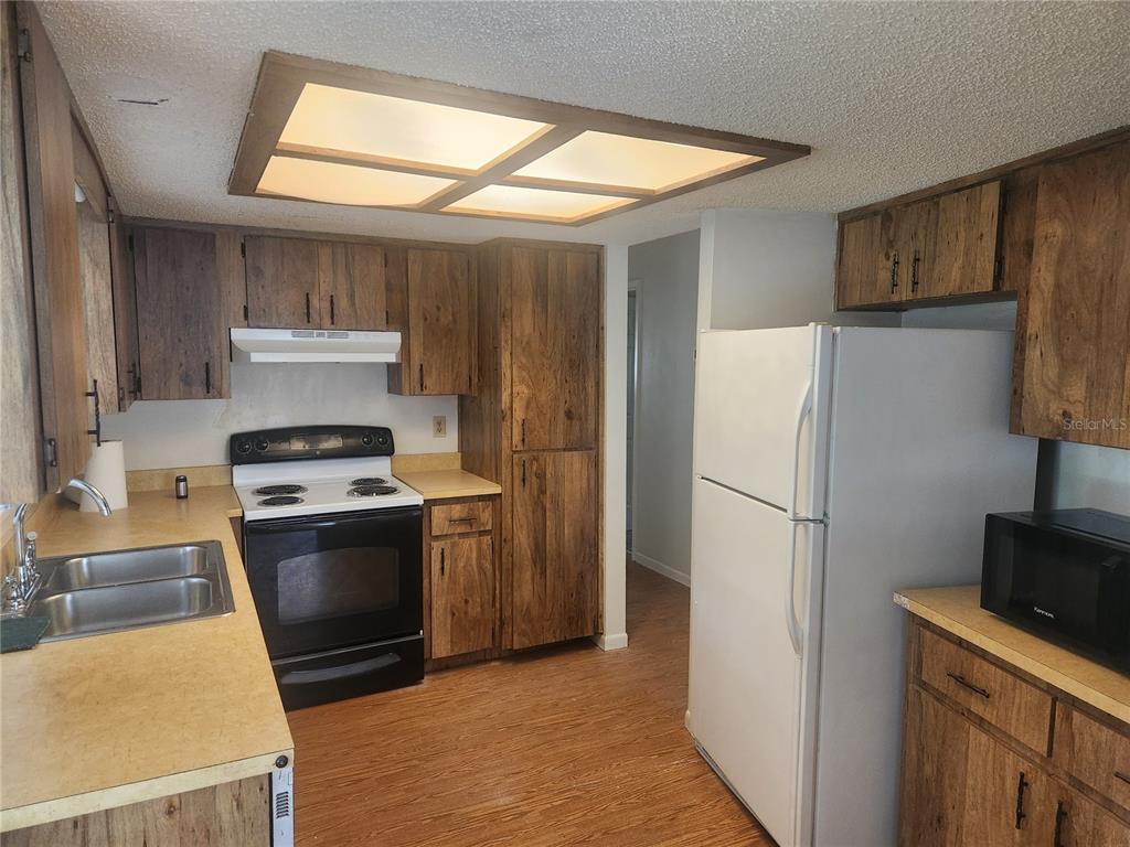 9075 Southwest 104th Lane Ocala, FL 34481 - Photo 2 of 11 a kitchen with a refrigerator sink and stove
