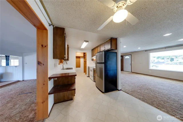a view of kitchen with refrigerator and window
