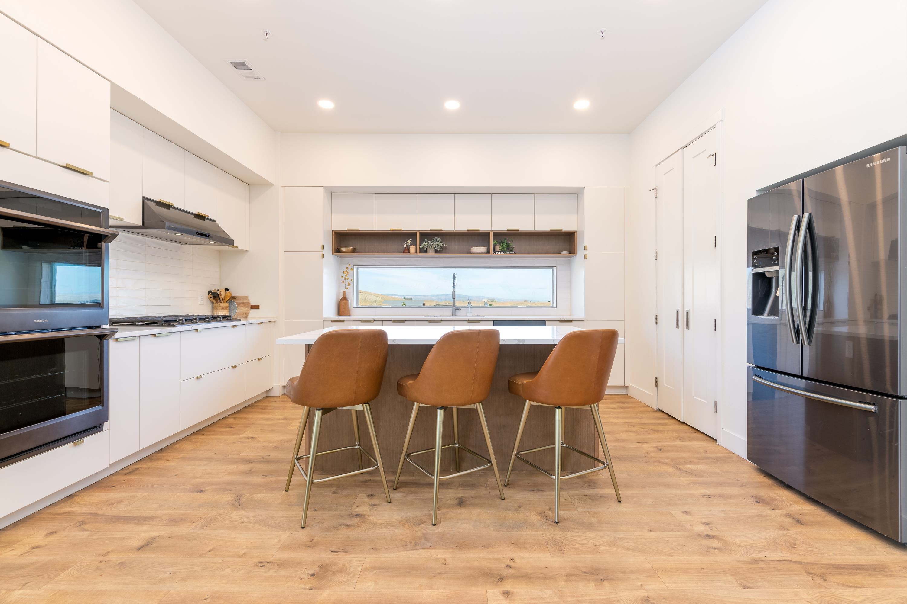 3685 East Road Palisade, CO 81526 - Photo 11 of 42 a kitchen with stainless steel appliances granite countertop a dining table chairs refrigerator and sink