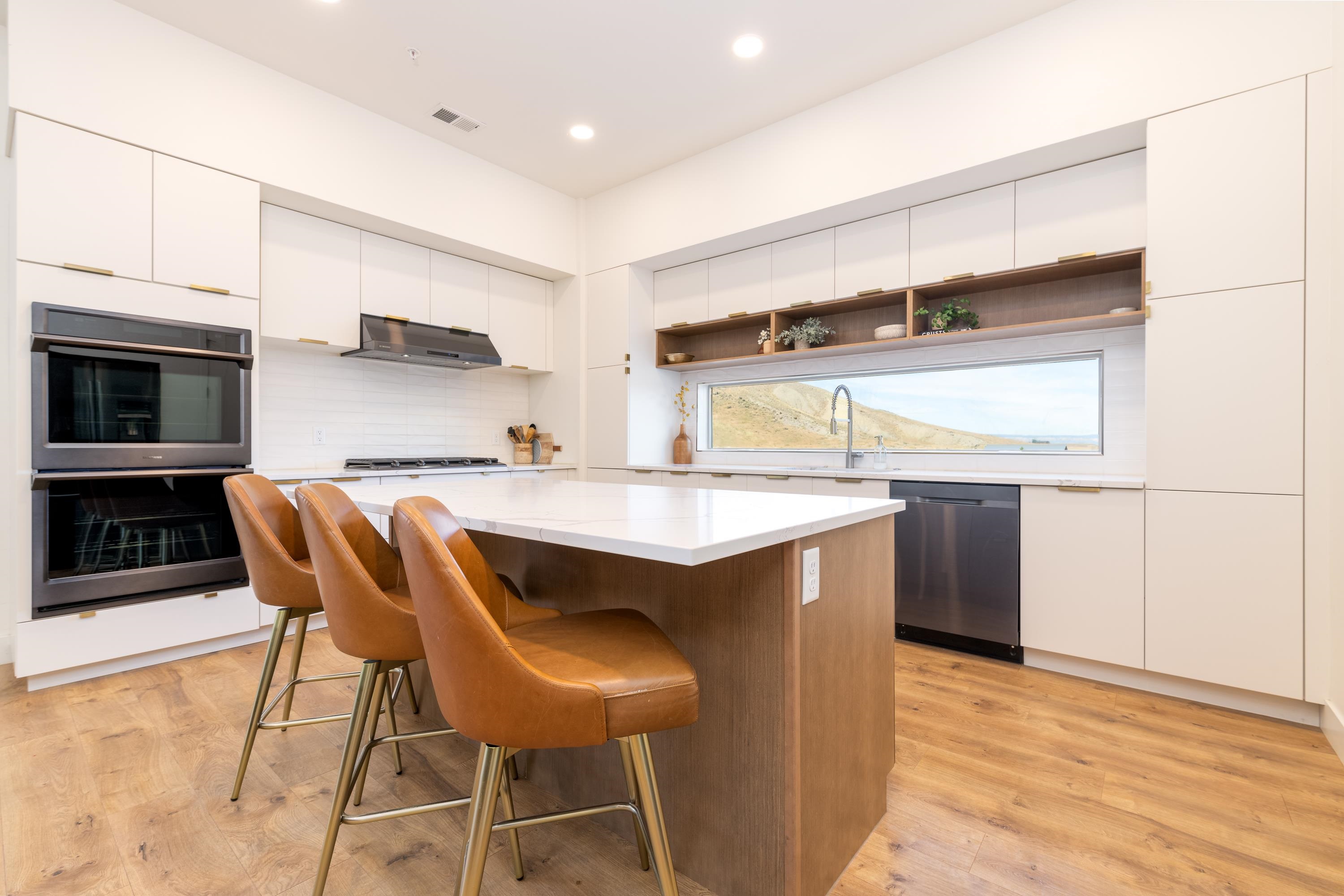3685 East Road Palisade, CO 81526 - Photo 14 of 42 a kitchen with stainless steel appliances kitchen island granite countertop a table chairs in it and wooden floors