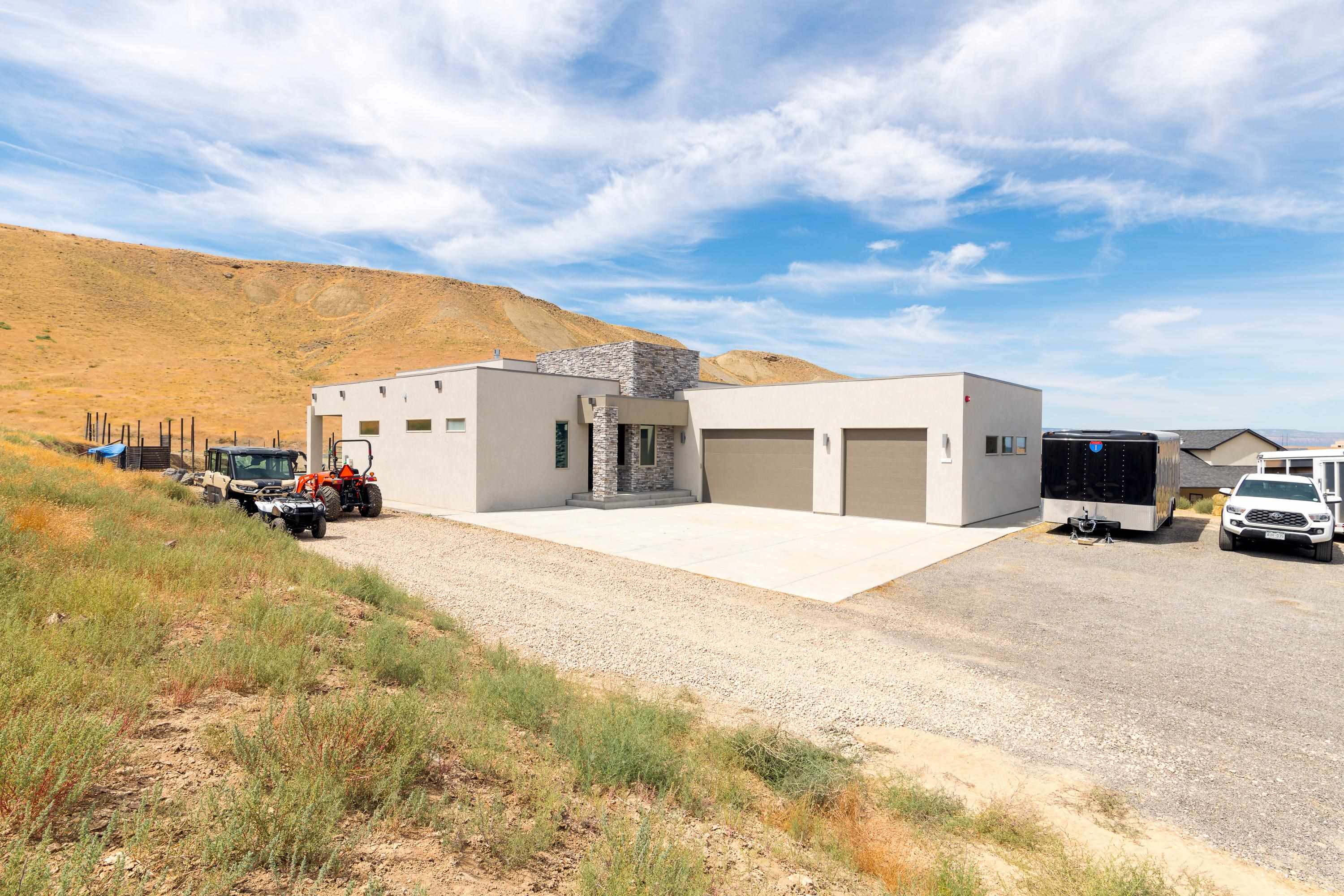 3685 East Road Palisade, CO 81526 - Photo 9 of 42 a view of a house with a barbeque and trees