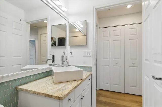 a spacious bathroom with a granite countertop sink and a mirror