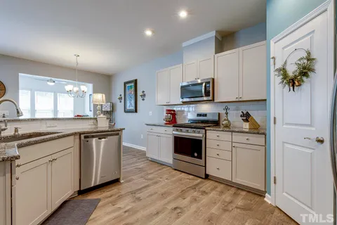 a kitchen with granite countertop white cabinets and white appliances