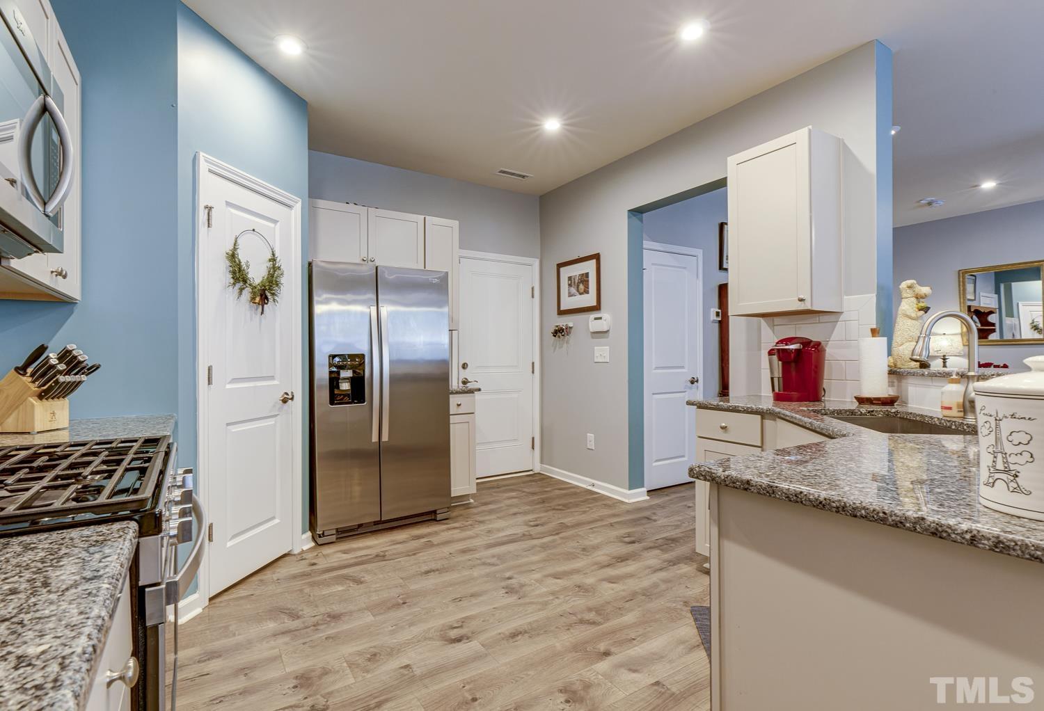 3155 Retama Run New Hill, NC 27562 - Photo 15 of 48 a kitchen with stainless steel appliances granite countertop a refrigerator and a sink