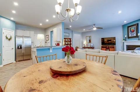 a kitchen with stainless steel appliances kitchen island granite countertop a table and chairs in it