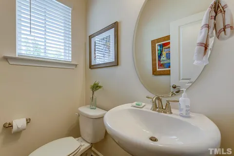 a bathroom with a sink and mirror with toilet