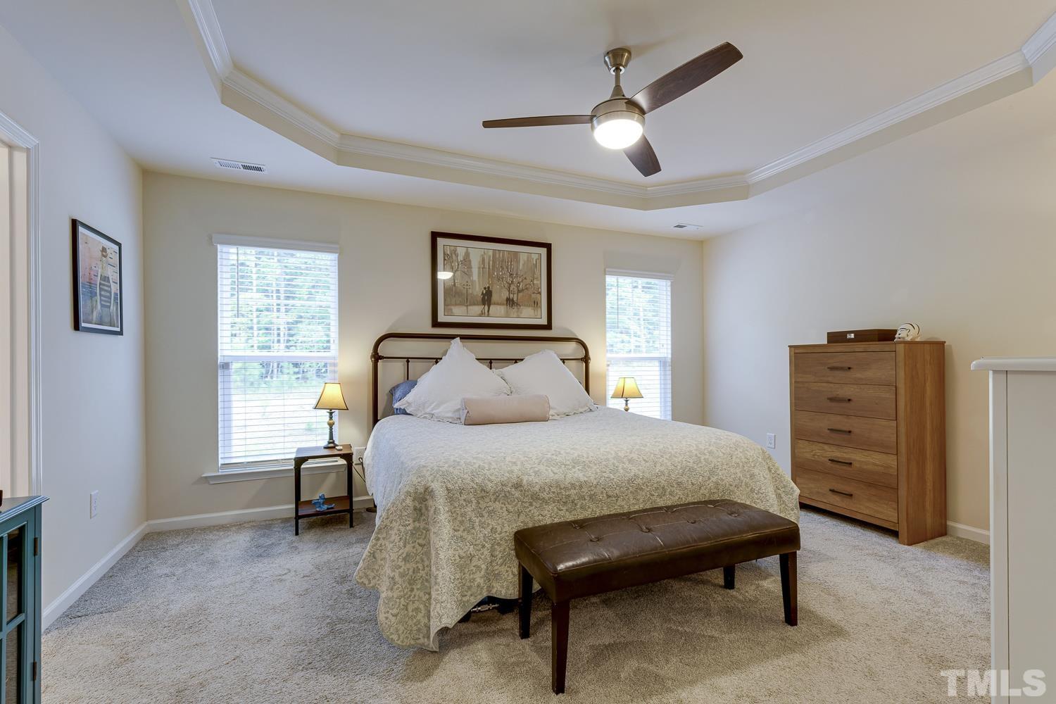 3155 Retama Run New Hill, NC 27562 - Photo 25 of 48 a bedroom with a bed and a chandelier